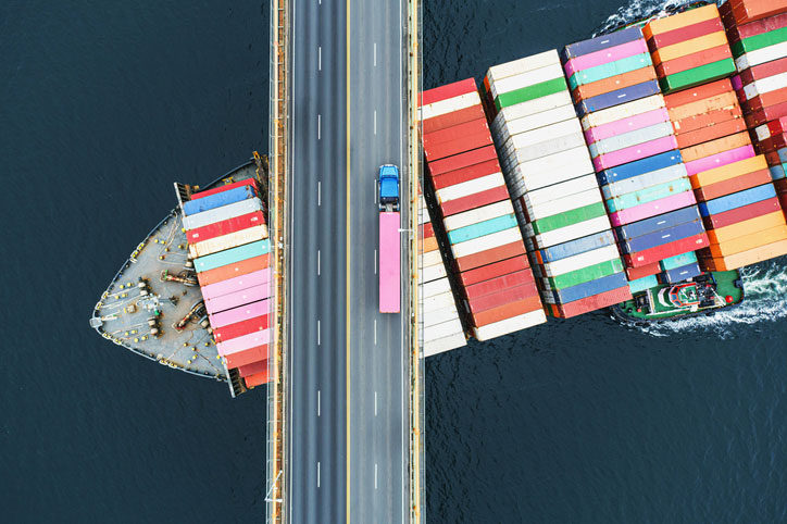 container ship below bridge