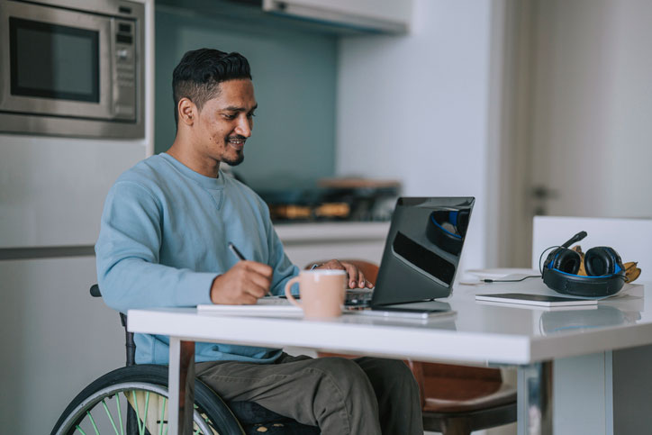 man in wheelchair working online