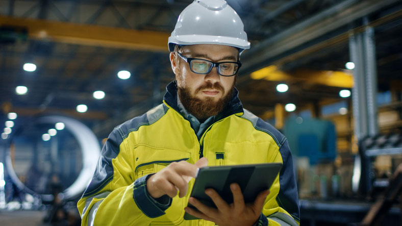 manager in hard hat using tablet