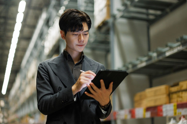 man using tablet in warehouse for logistics