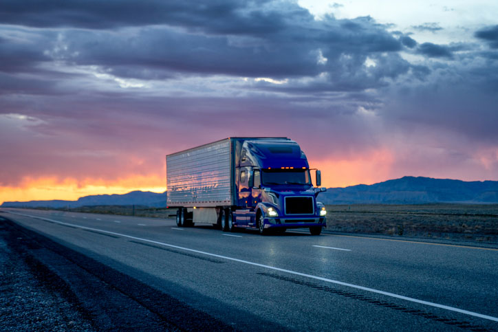 semi truck on highway at sunset