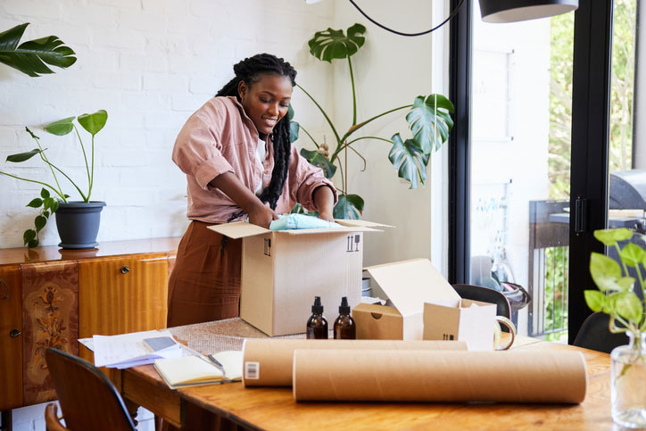 woman packing orders to mail out at home