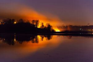 burning wildfires reflected on lake
