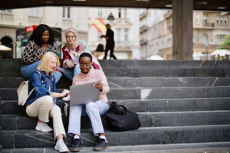 students sitting on the steps of campus