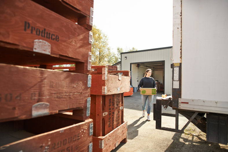 woman loading a truck at farm